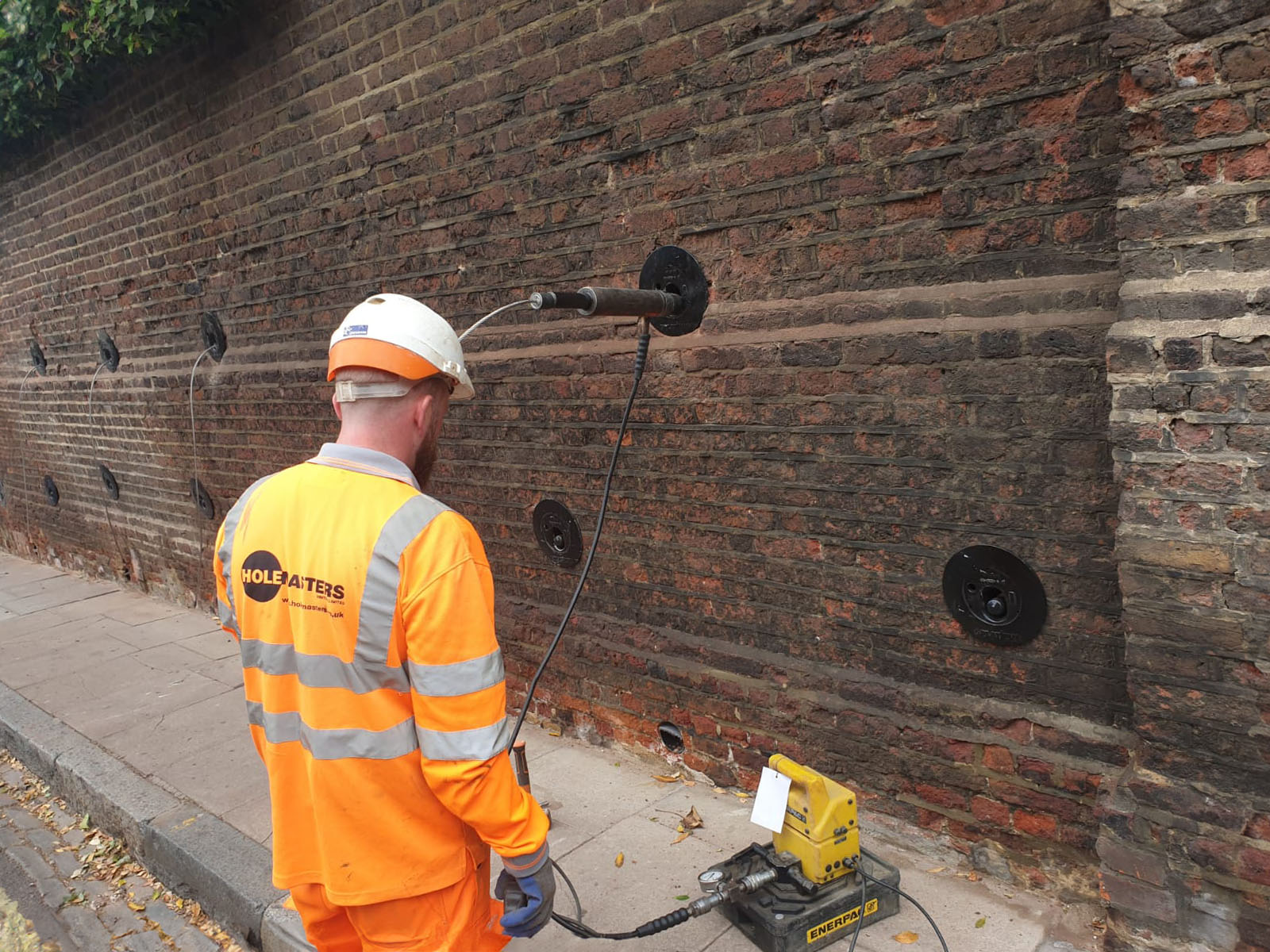 Ground anchoring installation on retaining wall